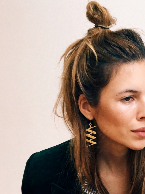 Chevelure noue de manire dsinvolte + longues boucles d'oreilles dores = le bon mix