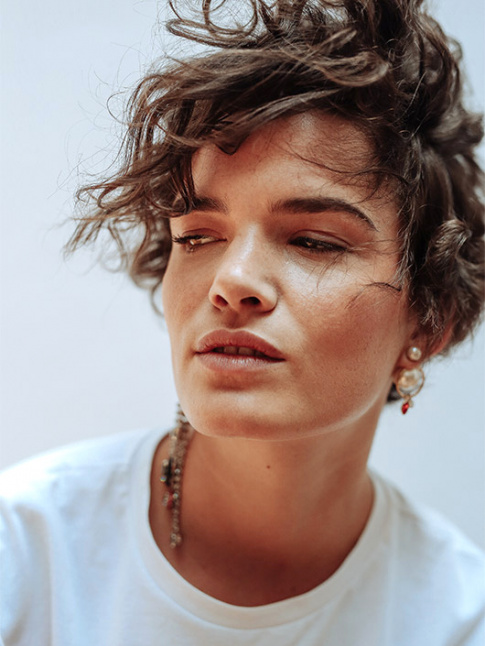 Tee-shirt blanc + coupe courte boucle + boucles d'oreilles audacieusement fantaisies = le bon mix