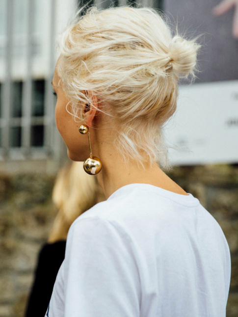 Rien de tel qu'une audacieuse paire de boucles d'oreilles pour booster le duo petit chignon/tee-shirt blanc !