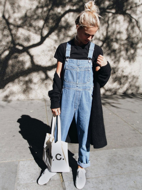 Salopette en jean roulotte sur la cheville + maxi gilet noir + chignon haut blond = le bon mix