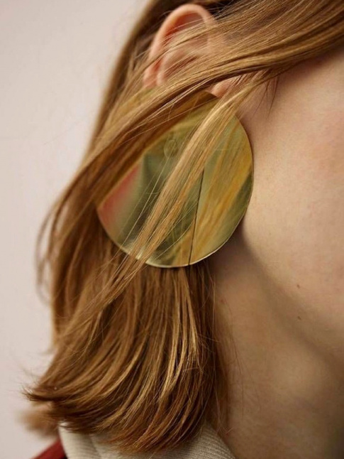 Oui aux maxi boucles d'oreilles patines par quelques mches de cheveux !