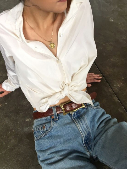 Chemise blanche noue sur le devant + jean droit taille haute + mdaille dore = le bon mix