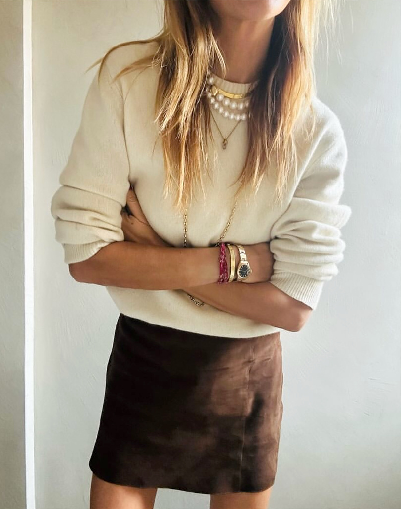 Mini jupe en daim marron + gros pull blanc cassé + accumulation de bijoux = le bon mix