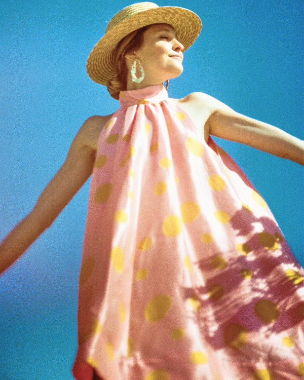Robe rose à pois et chapeau en paille