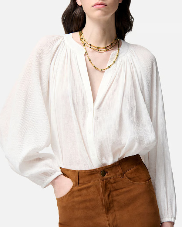 Blouse blanche ample et texturée à manches volumineuses portée avec une jupe marron