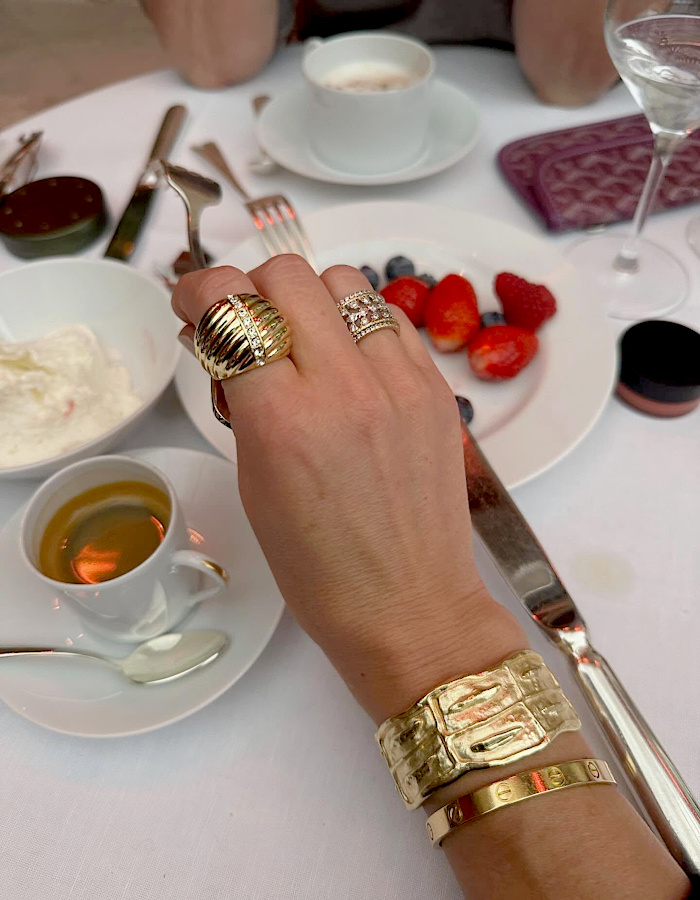 Bagues et bracelets dorés coordonnés sur une main féminine