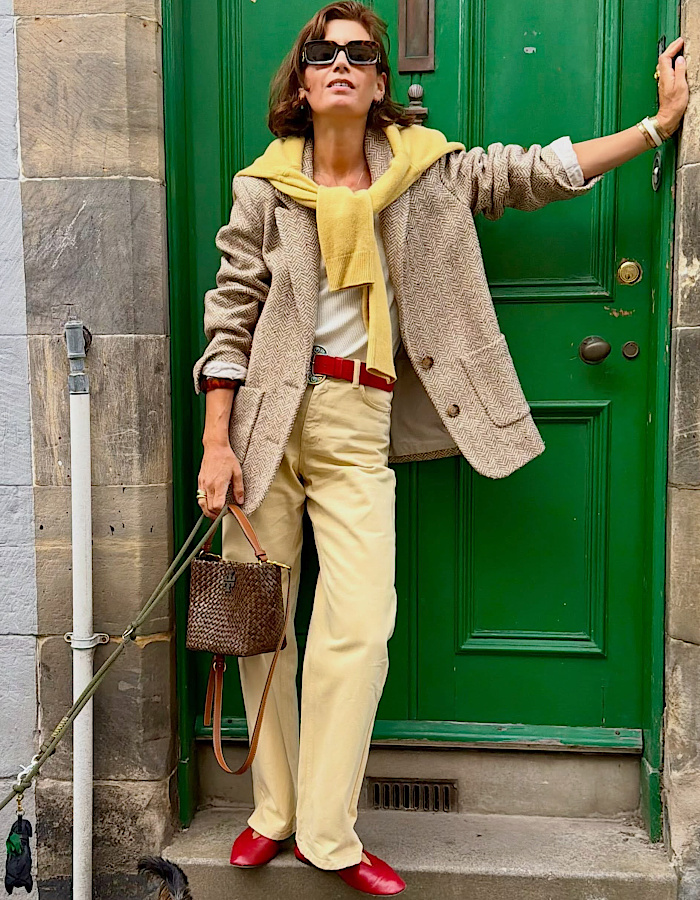 Blazer beige, pull jaune, pantalon crème et accessoires rouges